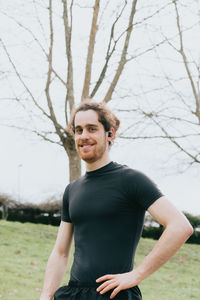 Portrait of man standing against bare tree outdoors