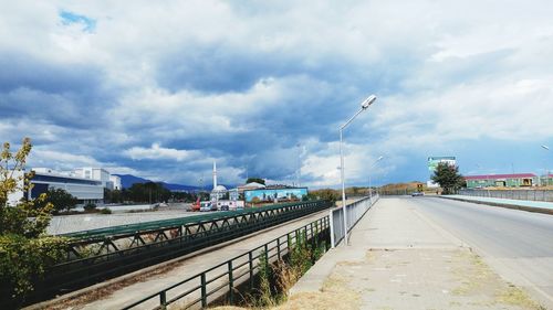 Railroad tracks against cloudy sky