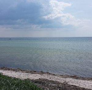 Scenic view of sea against cloudy sky