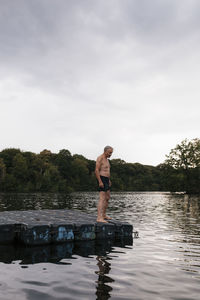 Senior man standing on raft in a lake