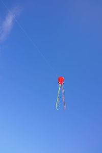 Low angle view of kite flying against clear blue sky