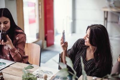 Young woman using smart phone on table