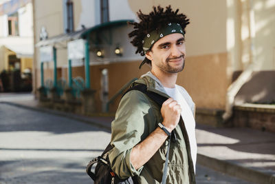 Portrait of smiling young man standing on street