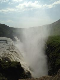 Scenic view of waterfall against sky