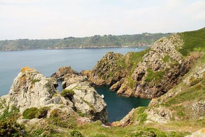 Scenic view of sea and mountains against sky