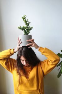 Young woman standing against wall