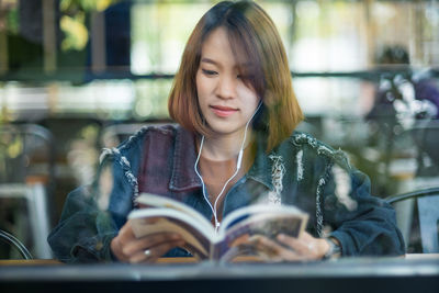 Woman reading book at cafe