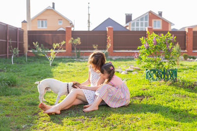 Woman with arms raised against house in yard