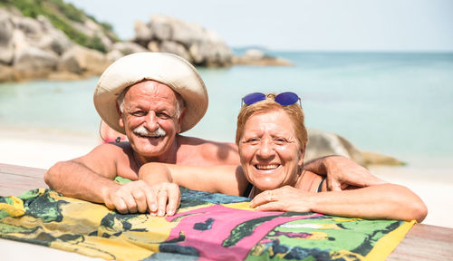 Portrait of happy senior couple standing at beach