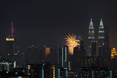 Firework display over city lit up at night