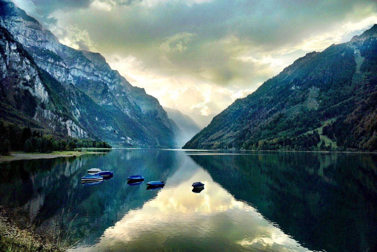 mountain, tranquil scene, scenics, water, lake, tranquility, reflection, mountain range, beauty in nature, waterfront, majestic, cloud - sky, nature, non-urban scene, sky, calm, outdoors, no people, tourism, vacations, remote, surrounding, physical geography