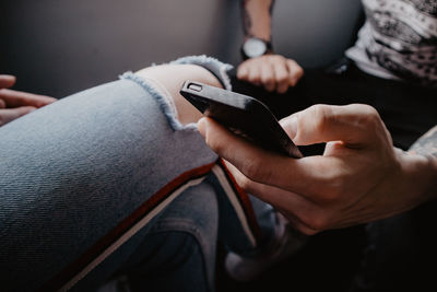 Midsection of man using mobile phone