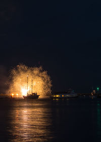 Illuminated ship in sea against sky at night