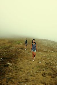 Full length of man walking on mountain against clear sky