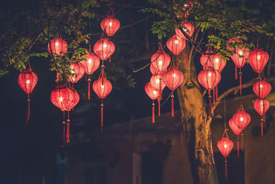 Low angle view of illuminated lanterns hanging at night