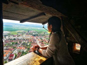 Young woman standing by cityscape in city