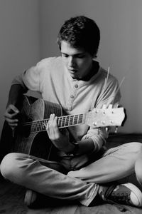 Young playing guitar at home