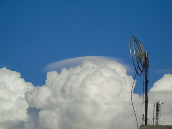 Low angle view of telephone pole against blue sky