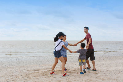 Happy family enjoying together on land against sky