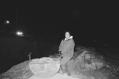 Woman standing on snow covered landscape at night