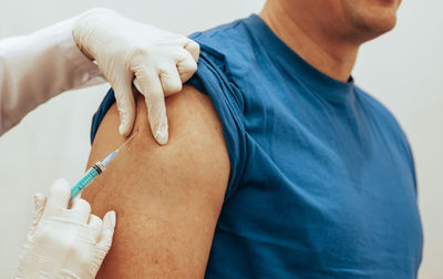 Midsection of man holding syringe