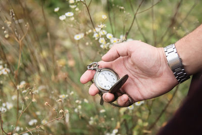 Time concept. new year midnight. close-up of old gold-plated pocket watch in male hand on natural 