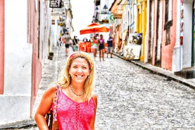 Portrait of smiling young woman in city