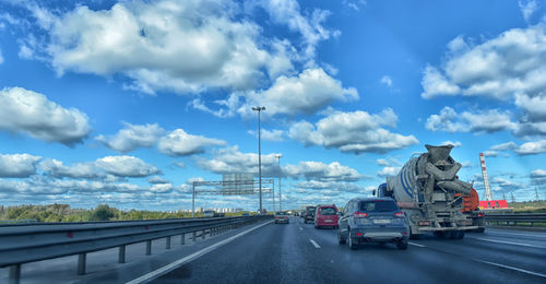 Cars on highway against sky in city