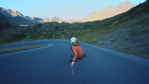 Rear view of woman walking on road