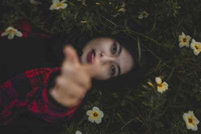 Portrait of cute girl with flowers on plant