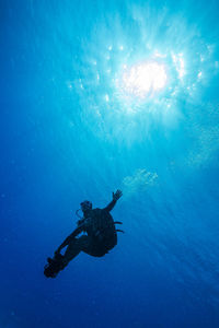 Low angle view of scuba diver swimming in sea