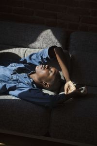 Portrait of young man lying down on sofa