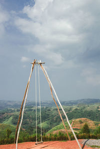 Metallic structure on field against sky