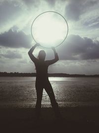 Silhouette person standing on beach against sky