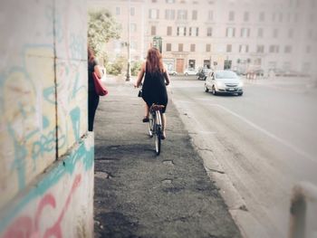 Man riding bicycle on street in city