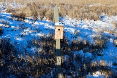 Snow on field by lake during winter