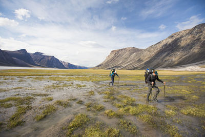 Two backpackers hike through a wet section of akshayak pass