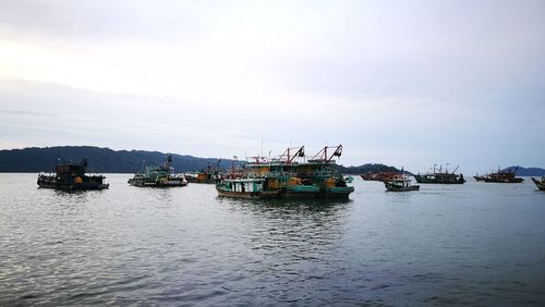 Boats sailing in sea against sky