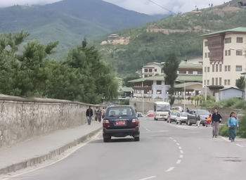 Cars on road by mountain against sky