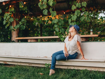 Full length of young woman sitting on bench