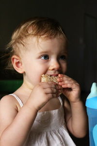 Close-up of girl eating sandwich at home