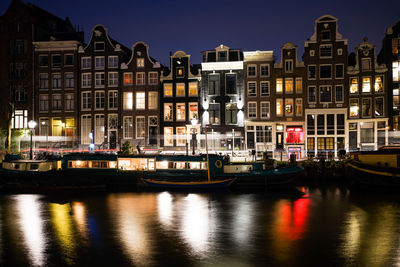 Boats moored in canal at night