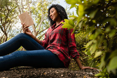 Portrait of young woman sitting on rock