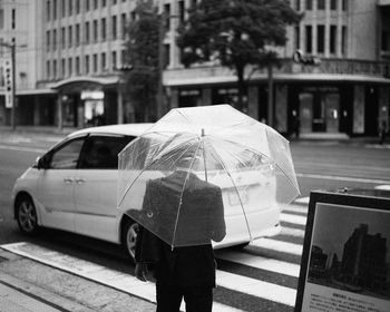 Man with umbrella on city street during rainy season