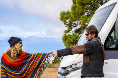 Mature couple holding hands standing by motor home