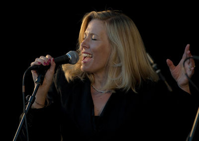 Close-up of woman singing using microphone