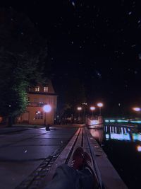 Illuminated street amidst buildings in city at night