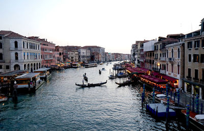 Canal amidst buildings against clear sky