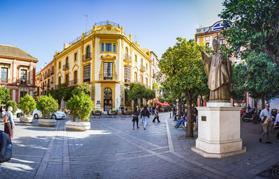 People walking on street against buildings in city