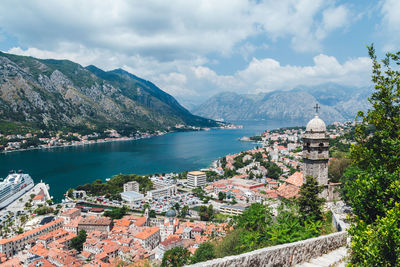 Panoramic view of townscape by sea and mountains against sky